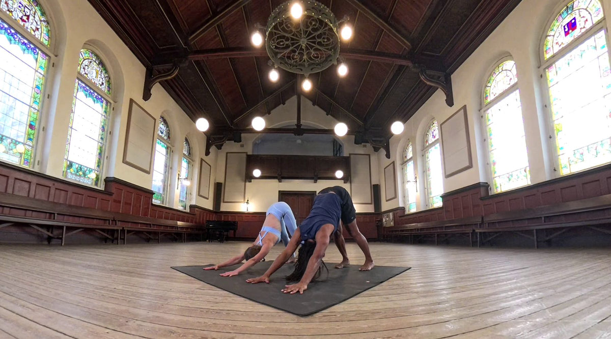 Eugene and partner practicing downward facing dog on the manduka pro squared mat