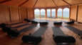 The Zen Den Yoga Studio setup showing 13 Manduka yoga mats looking out towards the sea