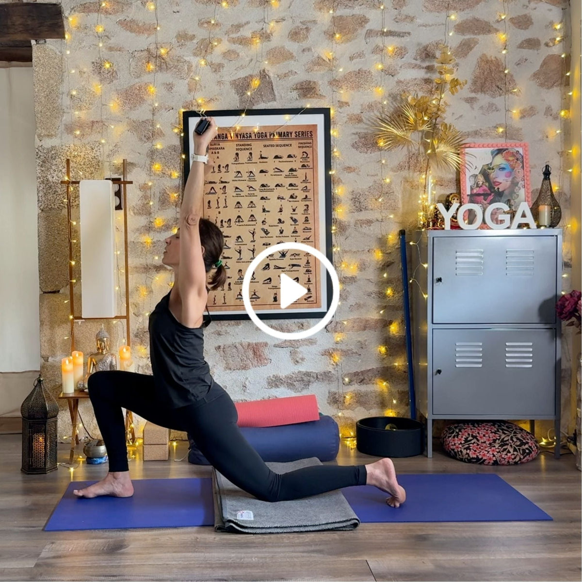 Person practicing a yoga lunge pose on a mat in a warmly lit, decorated studio.