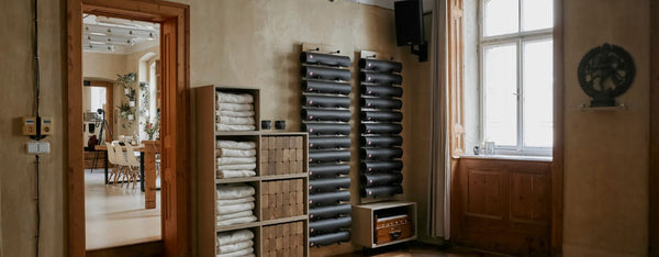 Room interior with shelves, rolled up Manduka yoga mats, and window