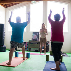 Linda with two students during a yoga class