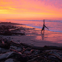 Linda somersaulting at the beach during sunset